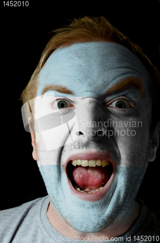 Image of Face of crazy angry man painted in colors of argentina flag