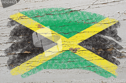 Image of flag of jamaica on grunge wooden texture painted with chalk  