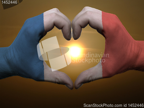 Image of Heart and love gesture by hands colored in france flag during be