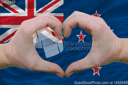 Image of Heart and love gesture showed by hands over flag of new zealand 