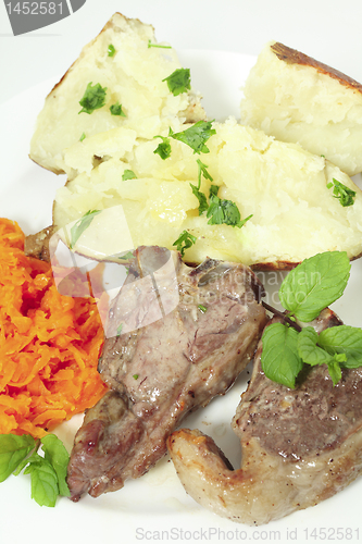 Image of Lamb chops carrots and baked potato vertical