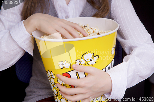 Image of hand in a bucket of popcorn