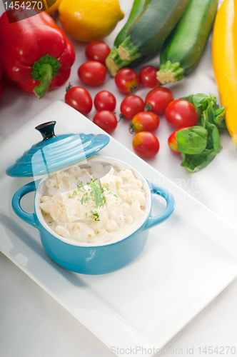 Image of mac and cheese on a blue little clay pot