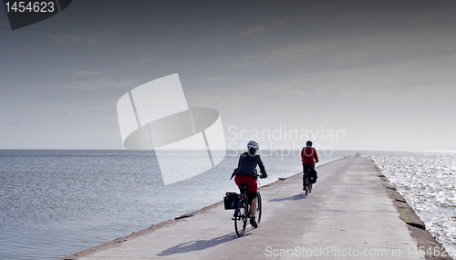 Image of Cyclists ride on concrete pier in Curonian Lagoon.