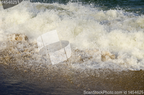 Image of Waves carrying sea sand on shore.