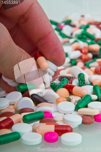 Image of hand grabbing pills