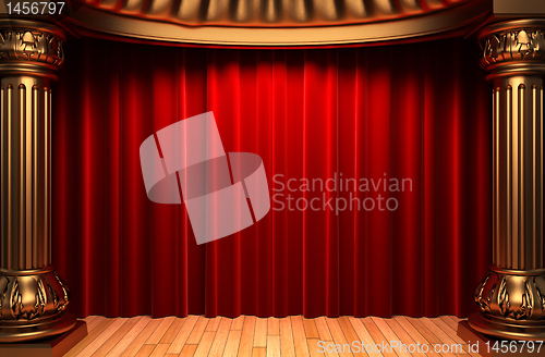 Image of red velvet curtains behind the gold columns