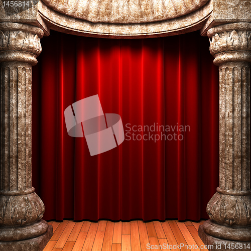 Image of red velvet curtains behind the stone columns