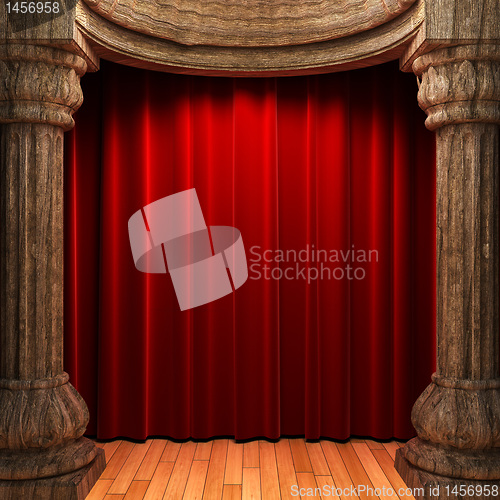 Image of red velvet curtains behind the old wood columns