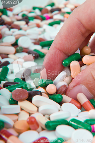 Image of hand grabbing pills