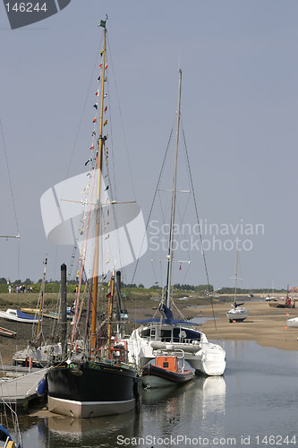 Image of tall boats at low tide