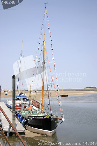 Image of tall boats at low tide