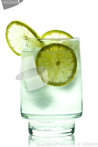 Image of Glass of gin and tonic with ice cubes and lime slices