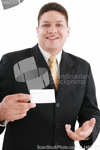 Image of young attractive businessman shows his business card, focus in m