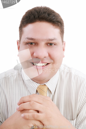 Image of Caucasian man with hands folded in front smiling at viewer. 