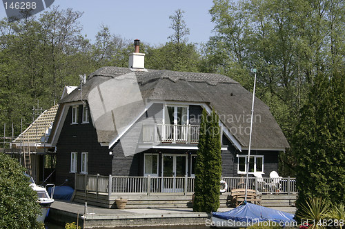 Image of thatched cottage with a boat