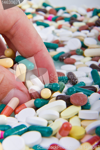 Image of hand grabbing pills