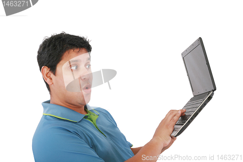 Image of Young man standing, holding a laptop computer, working, looking 