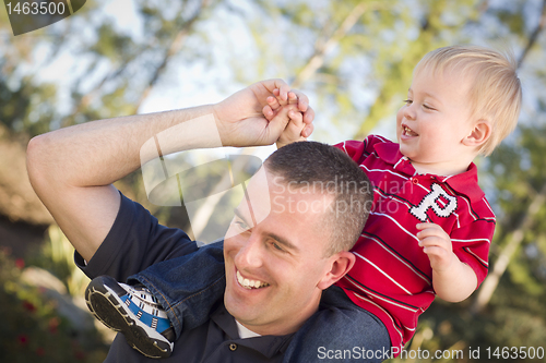 Image of Young Laughing Father and Child Piggy Back