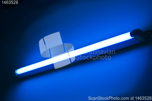 Image of Fluorescent lamp shining on blue colored wall