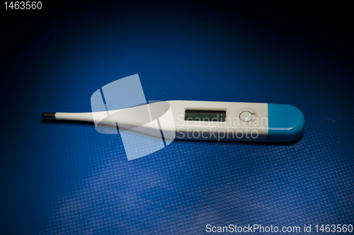 Image of Isolated thermometer laying on blue studio table