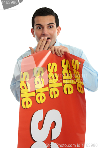 Image of Retail shopkeeper with sale sign, 