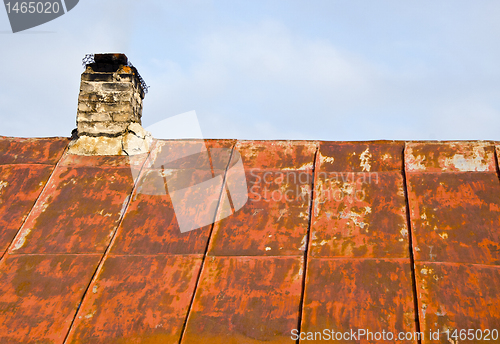 Image of Rusty roof tin and ramshackle brick chimney.