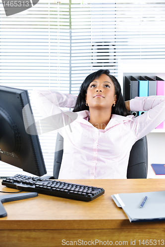 Image of Black businesswoman resting at desk