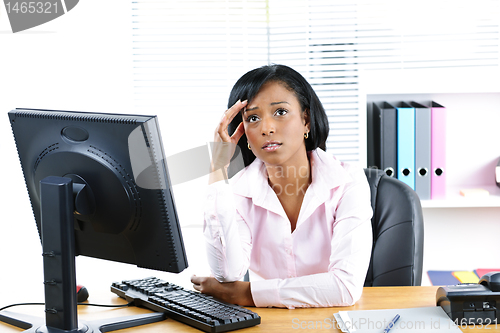 Image of Worried black businesswoman at desk