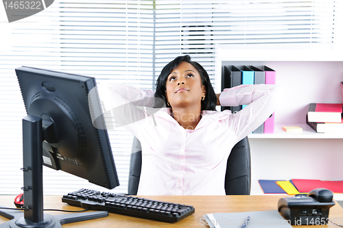 Image of Black businesswoman resting at desk