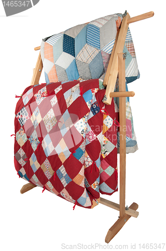 Image of Antique Quilts On Wooden Rack.