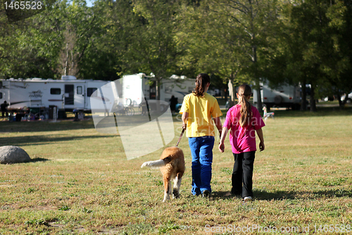 Image of Girls Walking a Dog While Camping 