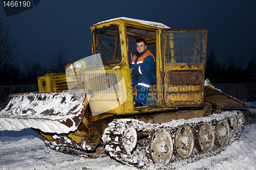 Image of Tractor clearing snow at night