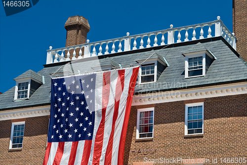 Image of Colonial Revival Style Building with Large American Flag Blue Sk