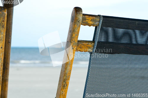 Image of Back of a Weathered Mesh Beach Chair with Ocean Background.