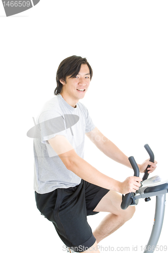 Image of Young Asian Man Riding Exercise Bike Isolated on White Backgroun