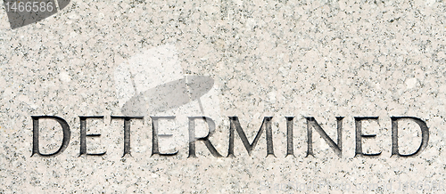 Image of Word "Determined" Carved in Gray Granite Stone