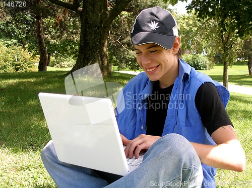 Image of Teenager outside happy with a laptop