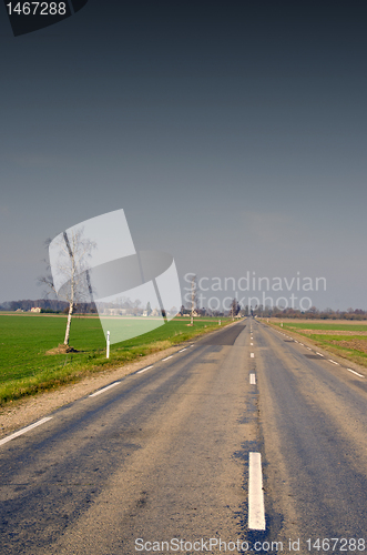 Image of Narrow paved and patched road. agricultural fields