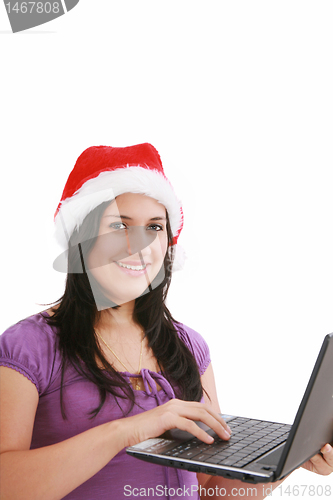 Image of Beautiful business woman is working in office in santa claus hat