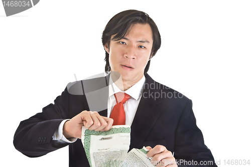 Image of Unhappy Asian Man Tearing Stock Certificate, Isolated White Back