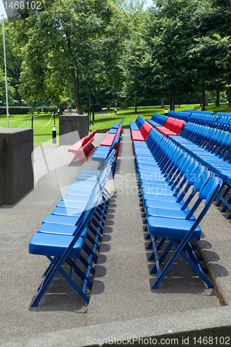 Image of XXXL Rows of Blue Red Metal Folding Chairs Outside