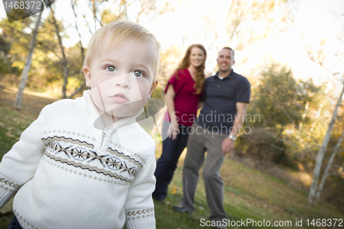 Image of Cute Young Boy Walking as Parents Look On From Behind