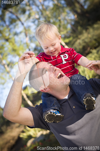 Image of Young Laughing Father and Child Piggy Back