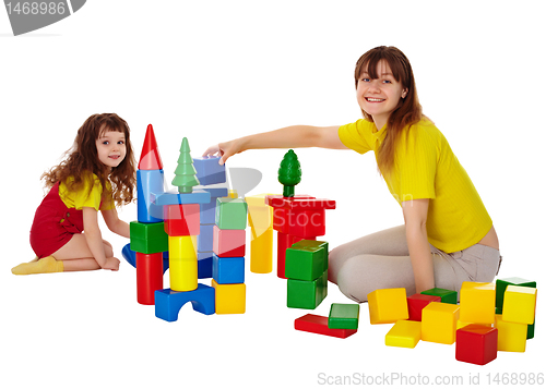 Image of Happy mother and daughter playing with blocks