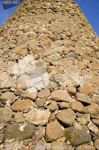 Image of Tall wall made of many different shape stones.
