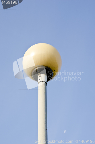 Image of Glass ball on metal pole. Park lighting.