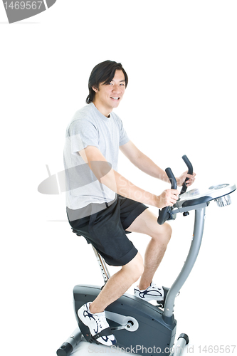 Image of Asian Man Riding Stationary Exercise Bike Isolated