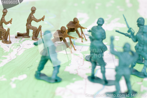 Image of Plastic Army Men Fighting on Topographic Map Opposing Sides War