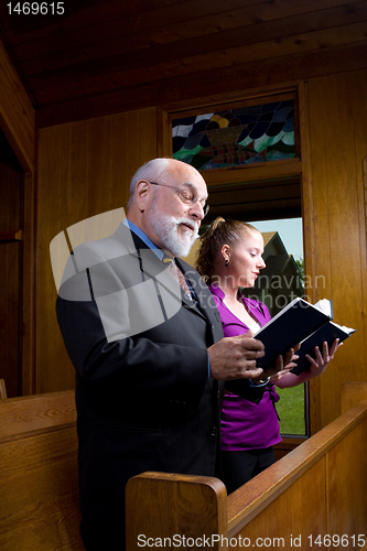 Image of Senior Man Young Woman Church Singing Hymnals